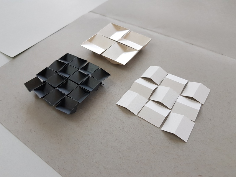paper models beside silver pieces