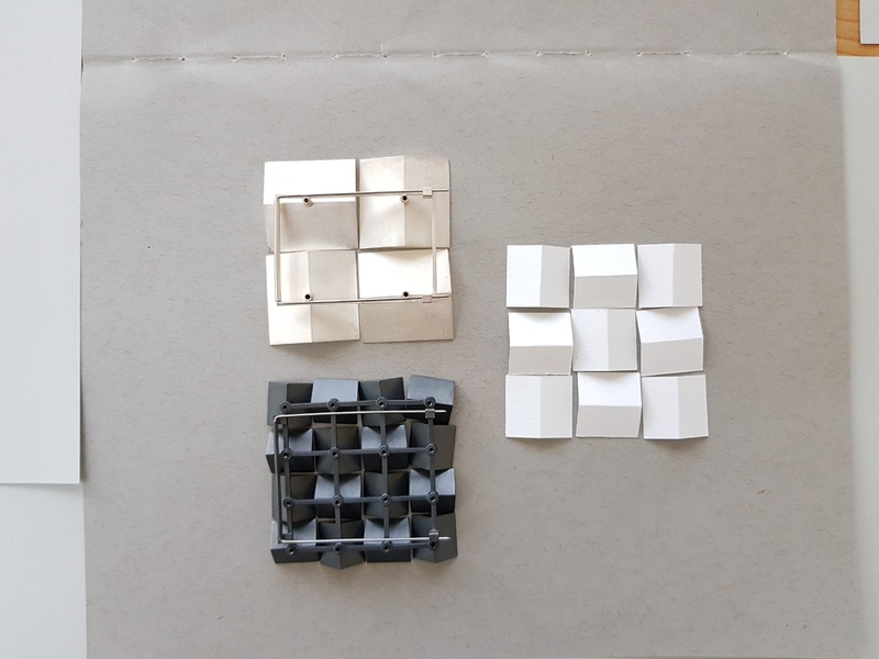 paper models and the backs of finished pieces showing the kinetic mechanism